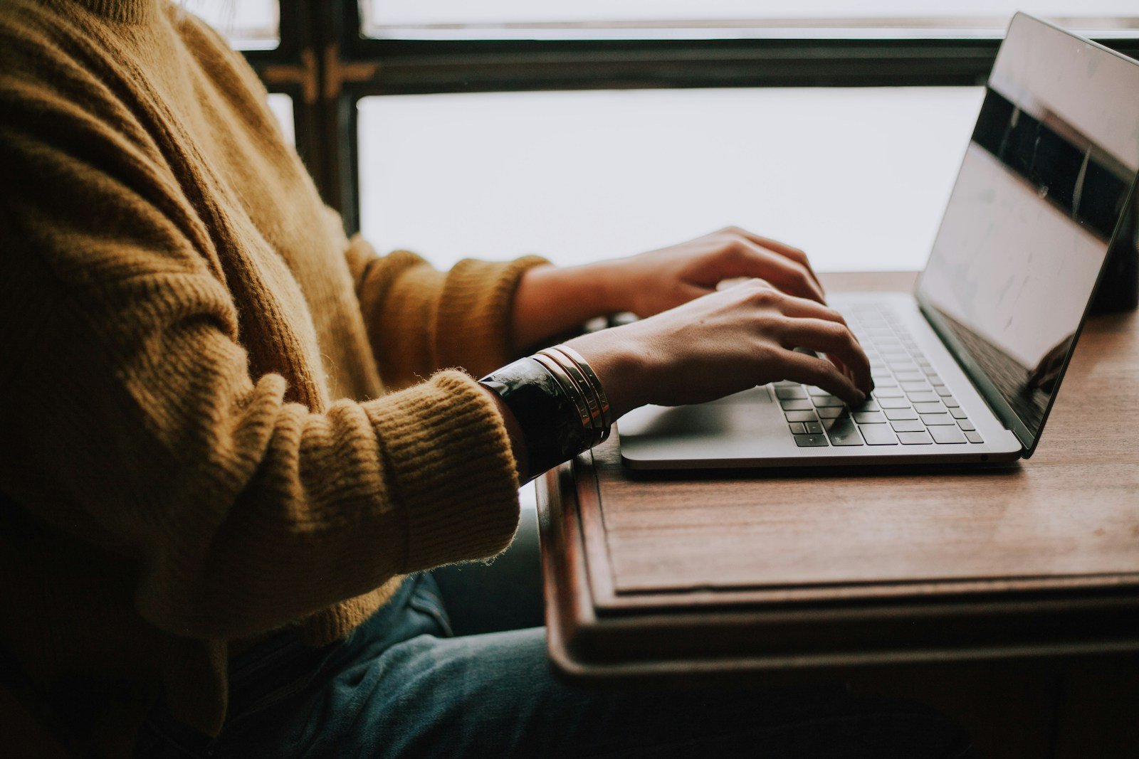 Person working on a laptop in a creative workspace